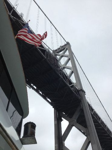 Under the Bay Bridge with US flag in wind