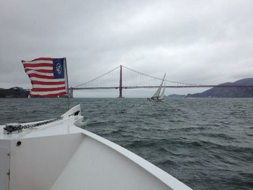 Flag on boat and Bay Bridge