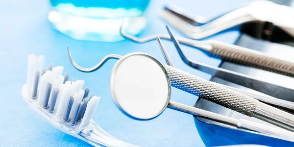 Dental tools and a toothbrush on a blue surface.