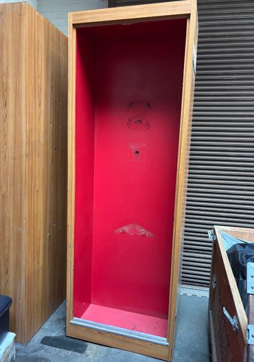 Empty wooden display cabinet with a red interior.