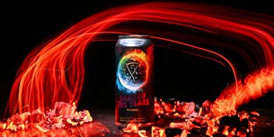A can with a fiery logo surrounded by glowing red light trails and scattered petals.