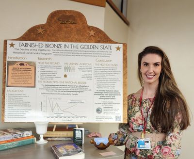 A graduate student presents a poster on California historical landmarks.