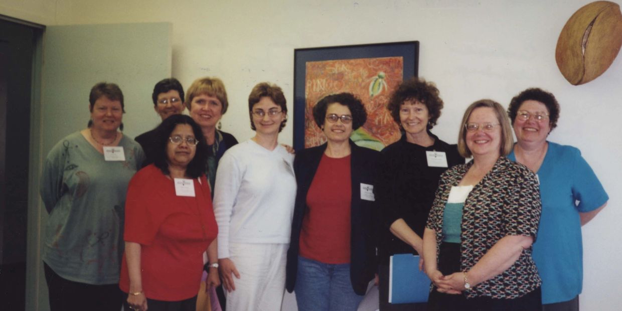 A group of nine members pose together at the 2001 conference. 
