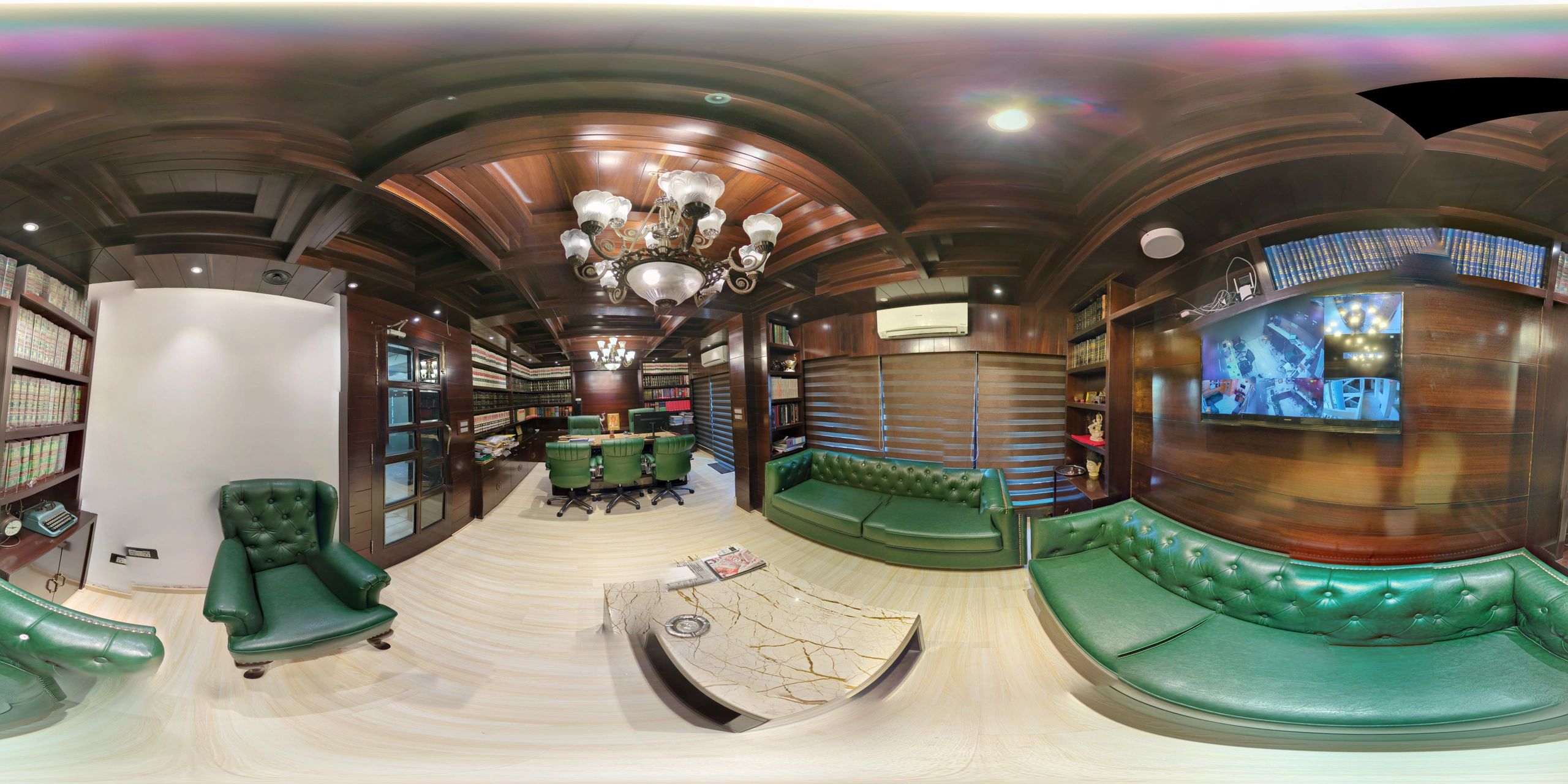 Luxurious office with green leather furniture and wooden shelves filled with books.