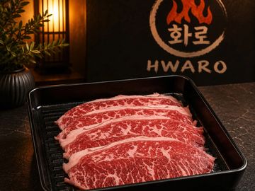 Thinly sliced marbled beef in a black tray, ready to cook.
