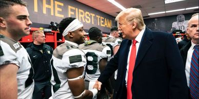 Trump shakes hand of black football player.
