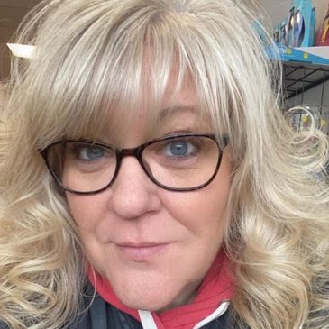 Two smiling female stylists, Sue and Betsy, wearing glasses and casual outfits.