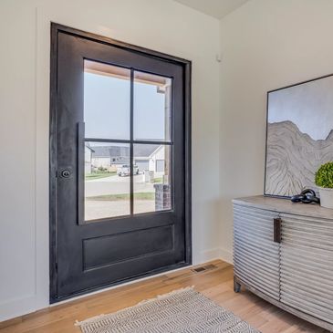 A steel pivot door in the entry of a classic house