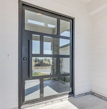 a modern pivot door on the entry of a house