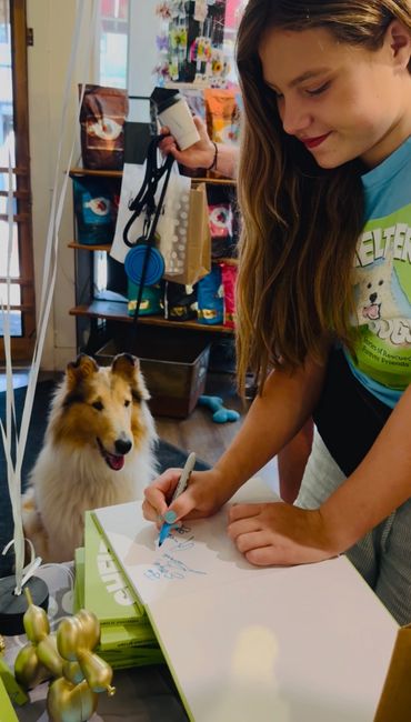 Amelie personalizes a copy of Shelter Dogs for her fan, Skye.