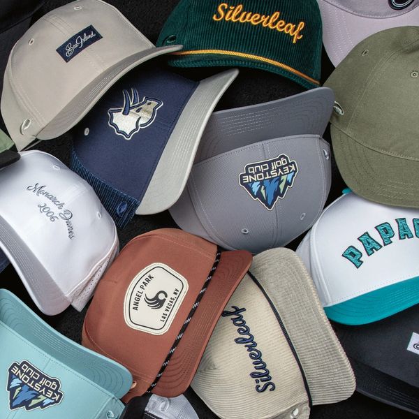 A collection of various embroidered caps with different logos and names.