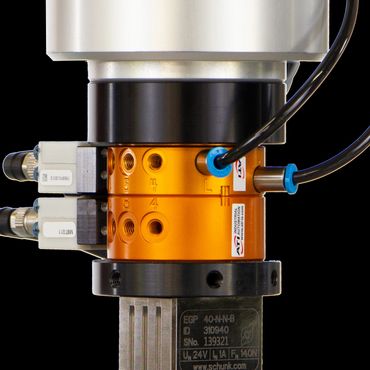 Close-up of a precision industrial robotic gripper with wiring and connectors.