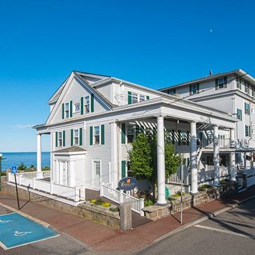 White house near the ocean under a clear blue sky.
