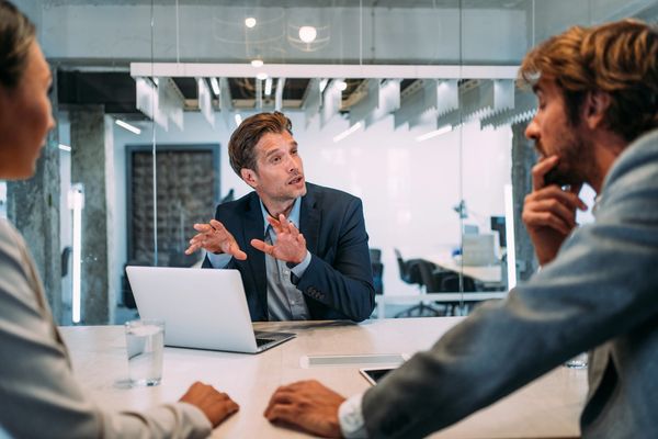 Businessman explaining a concept to two colleagues.