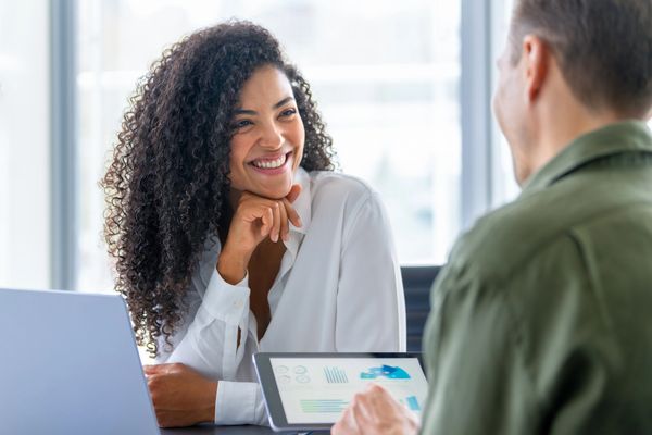 Smiling woman in a meeting looking at a colleague.