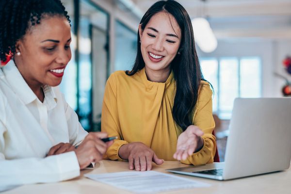 Two Smiling Business Women Reviewing Documents