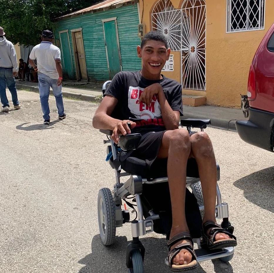 Dominican Teenager Darvin Smiles while sitting in his new electric wheelchair.