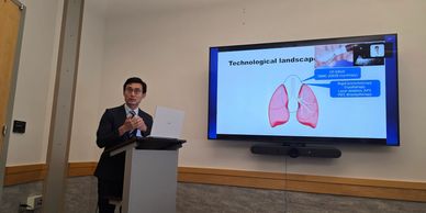 Man presenting lung technology on a screen in a conference room.