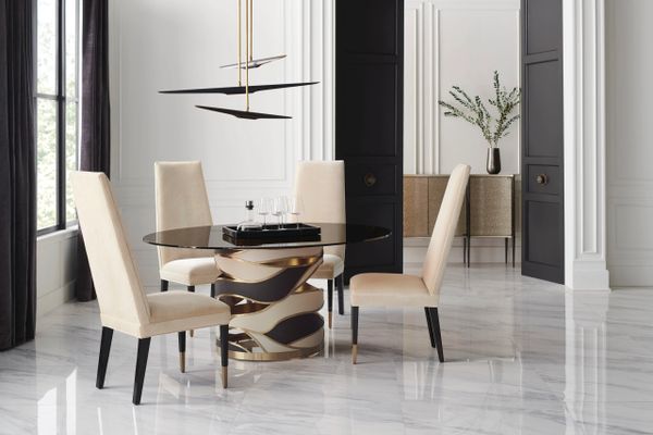 Elegant dining area with beige chairs and a sculptural table base.