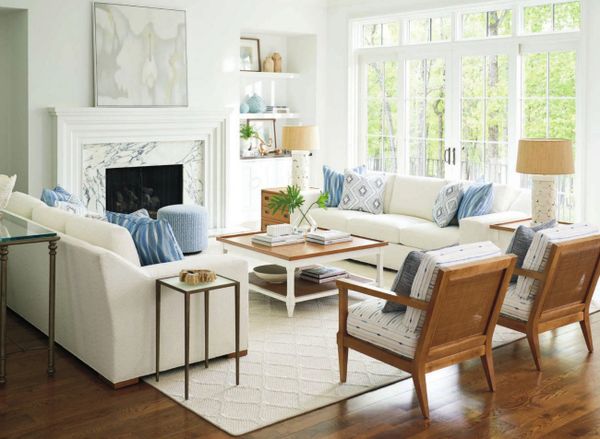 Bright, airy living room with white furniture and blue accents.