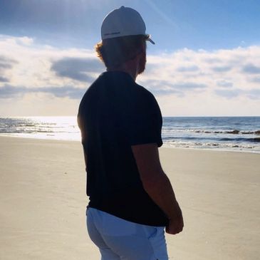 Man facing sunrise on a beach