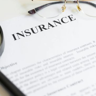 Insurance document with glasses and pen.