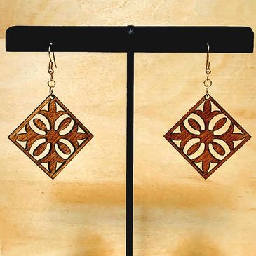 Wooden earrings with floral cutout design.