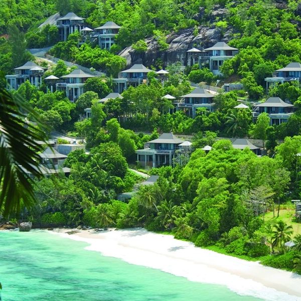 Luxury villas nestled in lush greenery by a pristine beach.