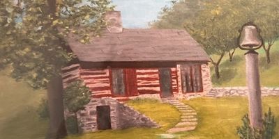 Rustic log cabin surrounded by greenery and a bell on a post.