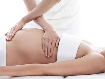 this is a prenatal massage with a pregnant person receiving a massage,