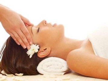 a lady relaxing laying down with temples being massaged.