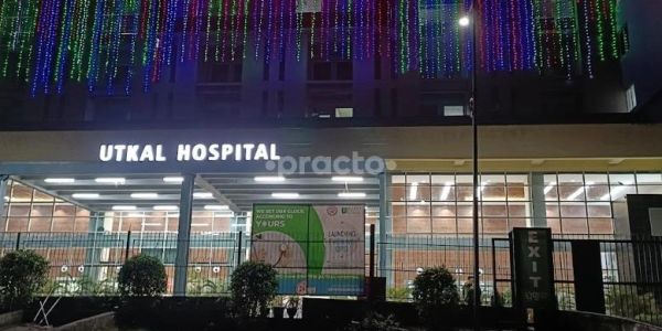 Utkal Hospital building illuminated with colorful lights at night.