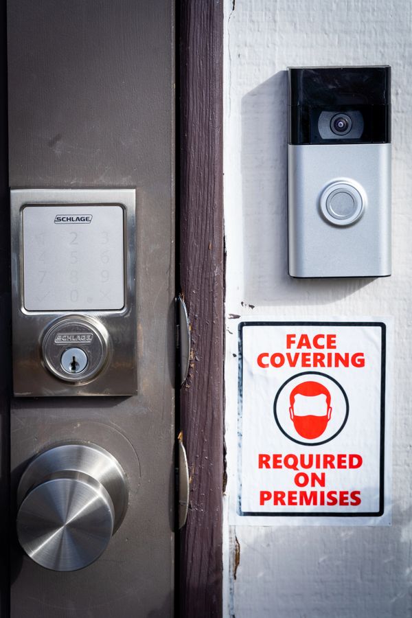 A silver and black doorbell near a wooden door