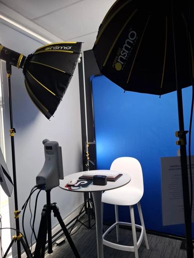 Photo studio setup with blue backdrop and lighting.