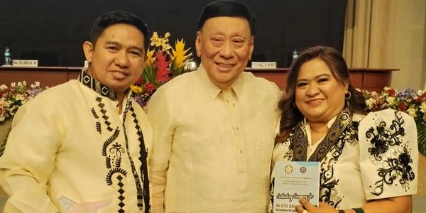 Three people in traditional Filipino attire smiling and posing together.