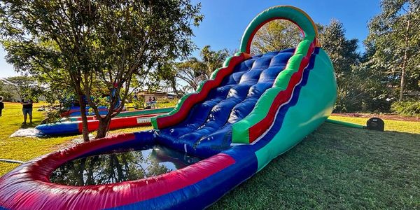 Colorful inflatable water slide in a sunny park setting.
