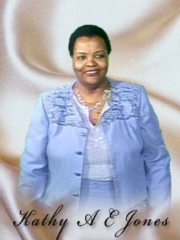 A woman in a light blue outfit smiling against a soft background.