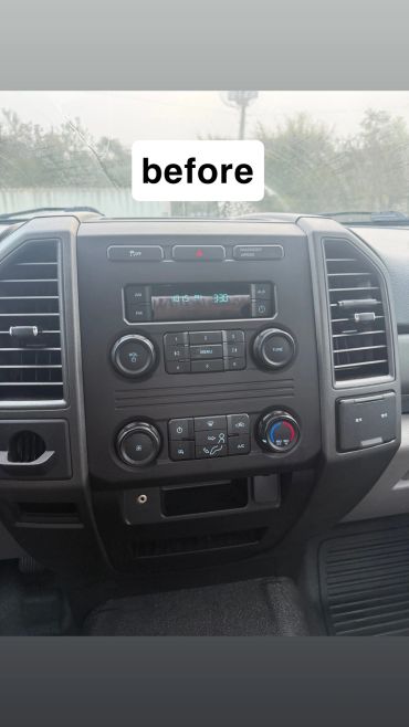 Car dashboard before cleaning, dusty windshield visible.