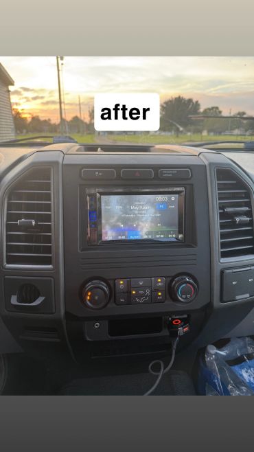 Vehicle dashboard with modern infotainment system and sunset view.