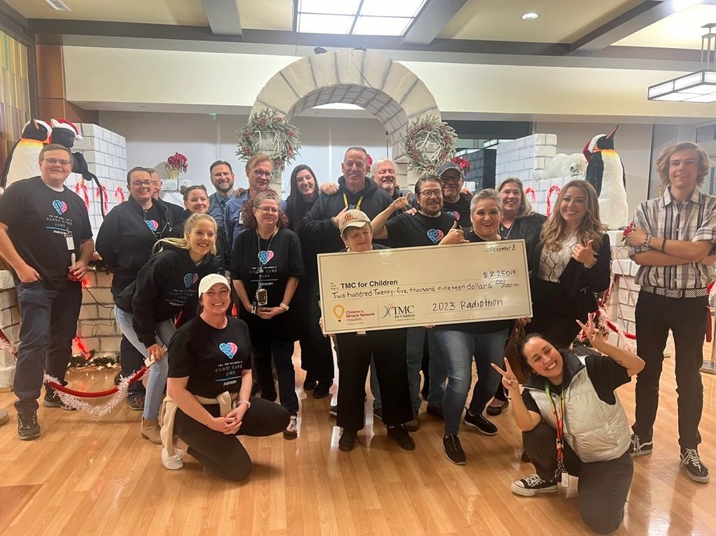 Group of people holding a large check for TMC for Children Radiothon.
