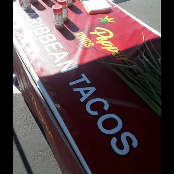 Red Caribbean Tacos banner with spice bottles on top.