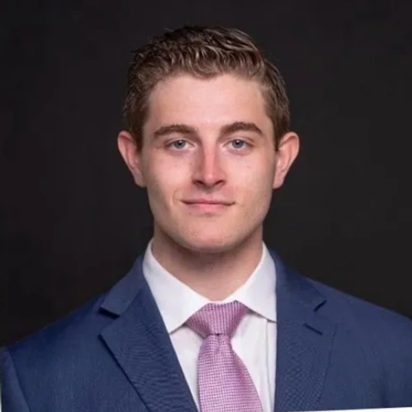 Young man in a blue suit and pink tie.