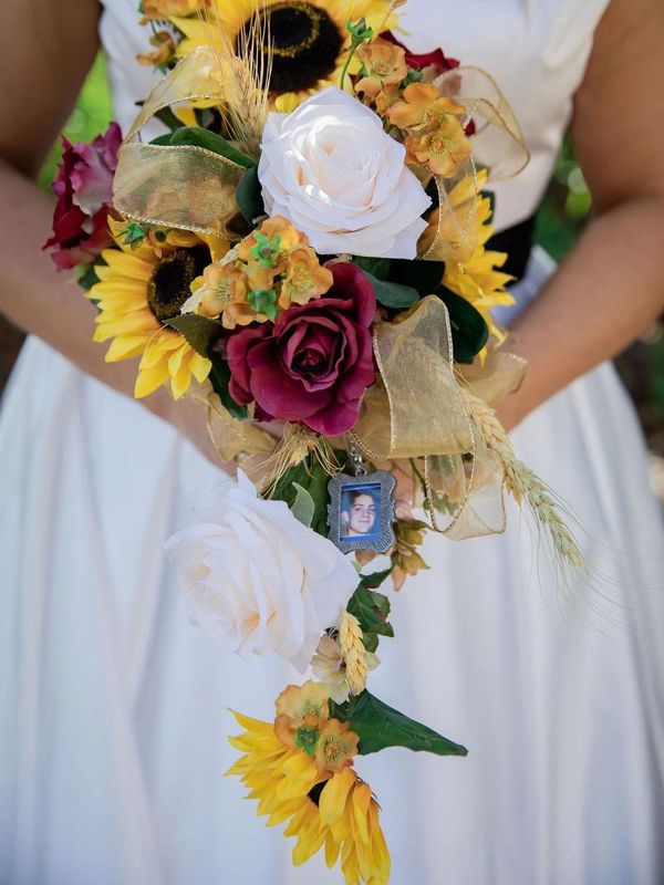 This Cascading Wedding Bouquet is created with Sunflowers, Ivory & Burgundy Roses and Gold Ribbons.