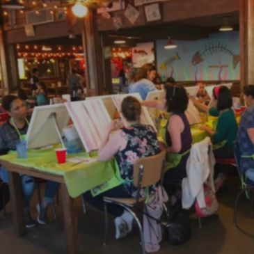 People enjoying a group painting class at a cozy art studio.