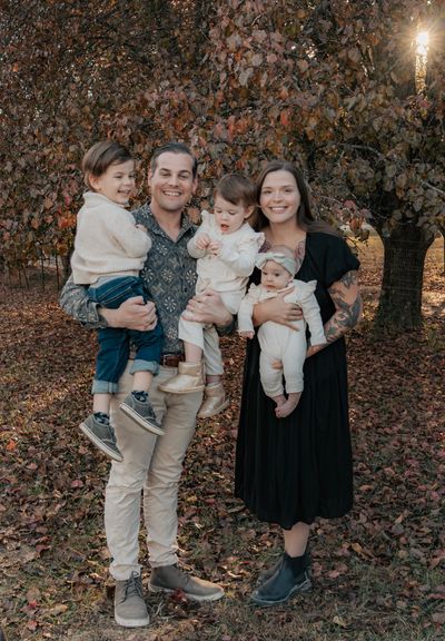 A happy family of five posing outdoors in autumn.