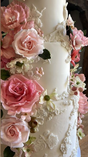 Close up of a bas relief cake - mix of pink sugar flowers, roses, cosmos, peonies, hydrangeas.