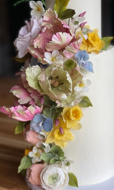 Close up of of sugar flowers - spring collection. Daffodils, tulips, runuculus. blue hydrangeas.