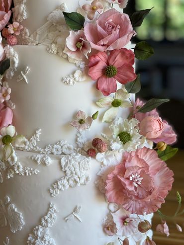 Close up of a bas relief cake - mix of pink sugar flowers, roses, cosmos, peonies, hydrangeas.
