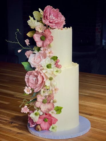 Close up of ganache wedding cake - mix of pink sugar flowers, roses, cosmos, peonies, hydrangeas.