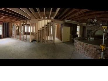 Interior of a house under renovation showing exposed framing and ceiling joists.